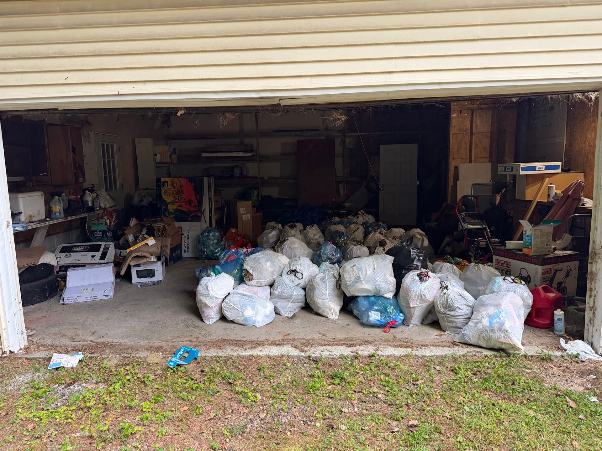 60+ trash bags staged for junk removal in a Vermont garage